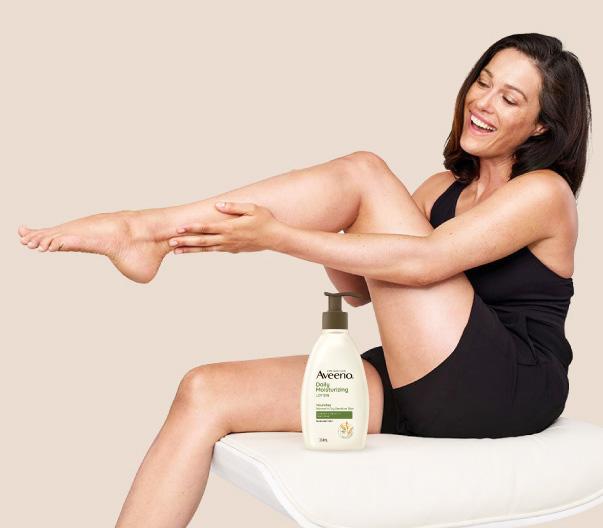 woman using aveeno body lotion for dry skin on legs